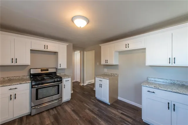 a kitchen with granite countertop a stove and a sink