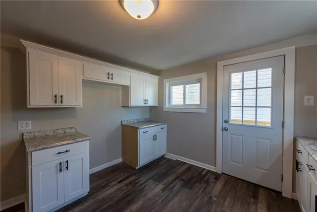 an empty room with wooden floor and cabinet