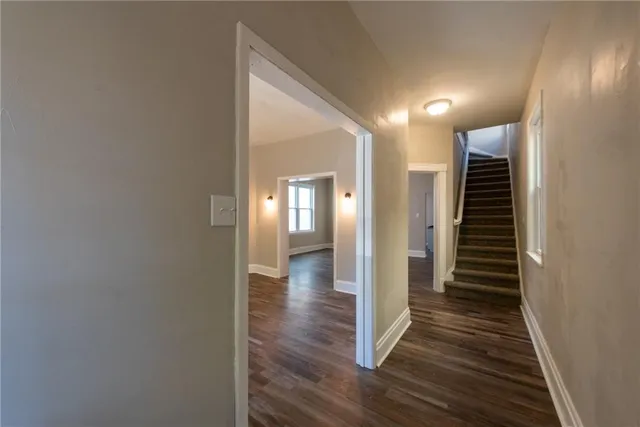 a view of a hallway with wooden floor and staircase