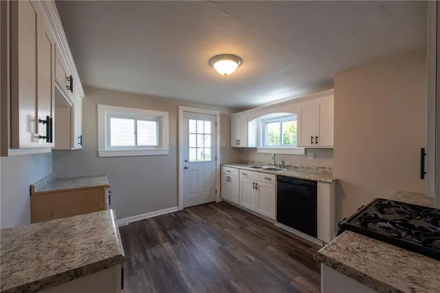 a kitchen with granite countertop a stove and cabinets