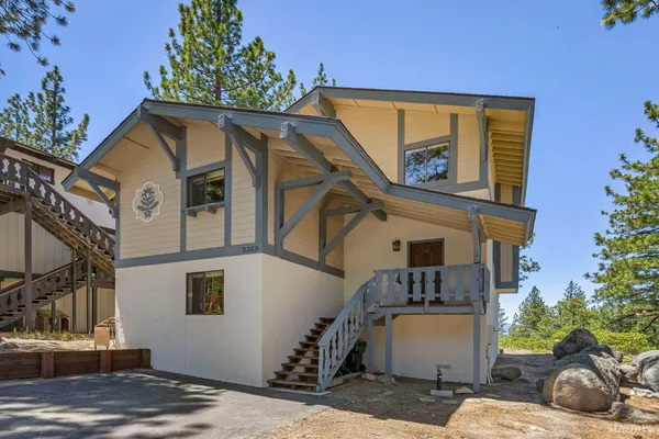a view of a house with a door and a tree