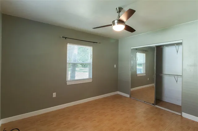 an empty room with closet and windows