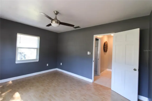 a view of a livingroom with a ceiling fan & window