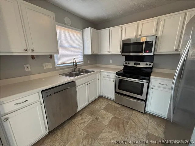 a kitchen with cabinets appliances and a window