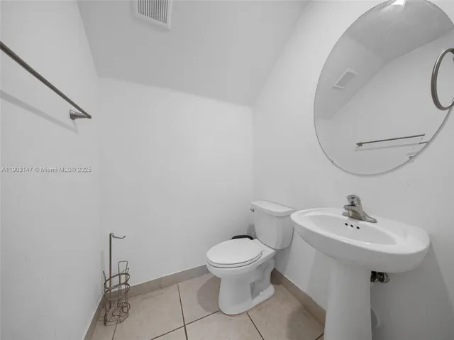 a kitchen with a refrigerator and white cabinets