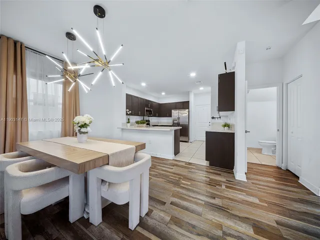 a kitchen with kitchen island granite countertop a sink a stove a refrigerator and cabinets