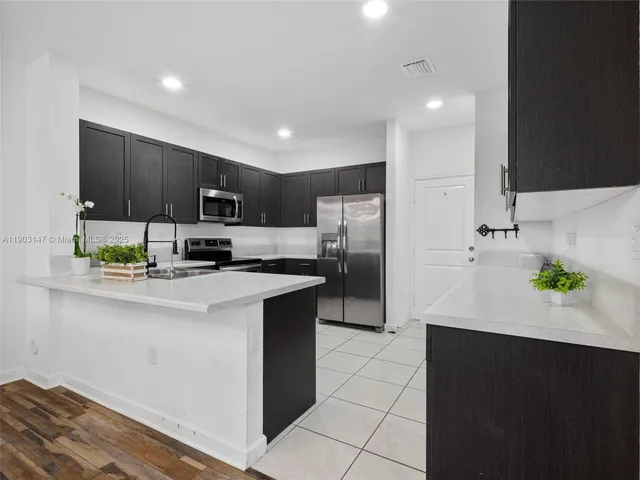 a large kitchen with stainless steel appliances lots of counter space sink and cabinets