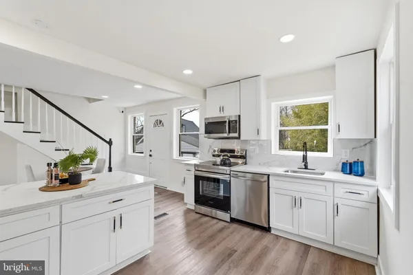 a kitchen with white cabinets and white appliances