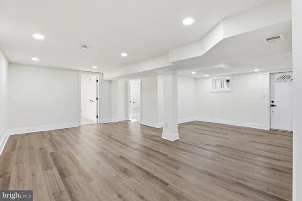 a view of an empty room with wooden floor