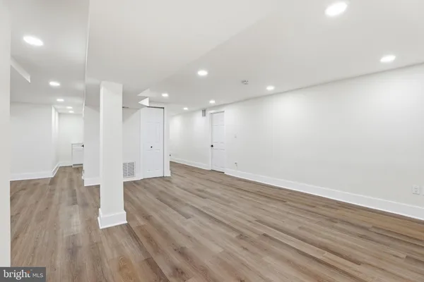 a view of an empty room with wooden floor