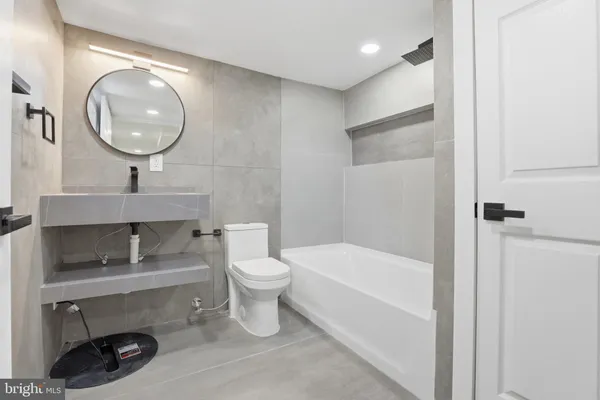 a bathroom with a toilet a sink and a mirror