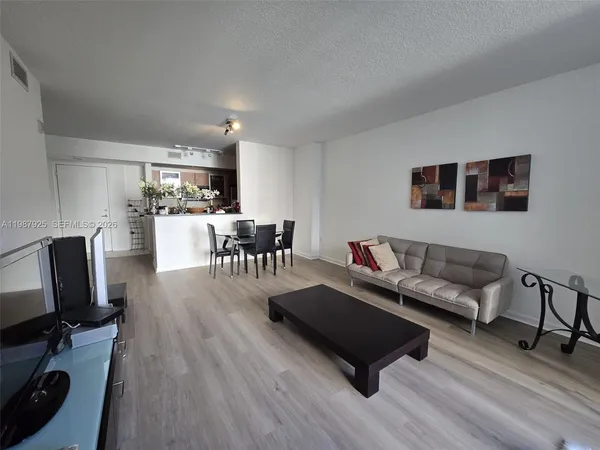 a living room with furniture wooden floor and a flat screen tv