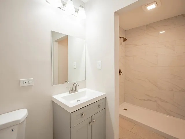 a bathroom with a sink a toilet and shower