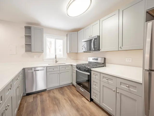 a kitchen with granite countertop cabinets stainless steel appliances a sink and a window