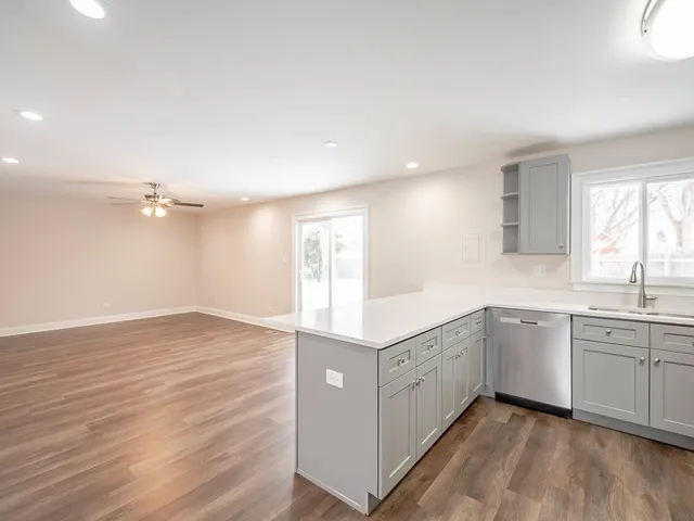 a kitchen with a sink cabinets and wooden floor