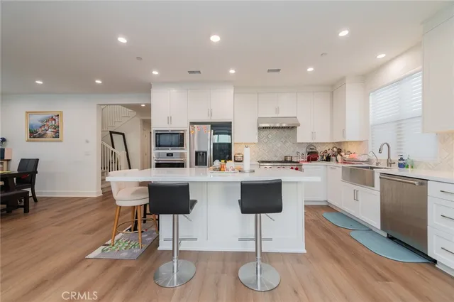 a kitchen with stainless steel appliances granite countertop a refrigerator and a stove top oven