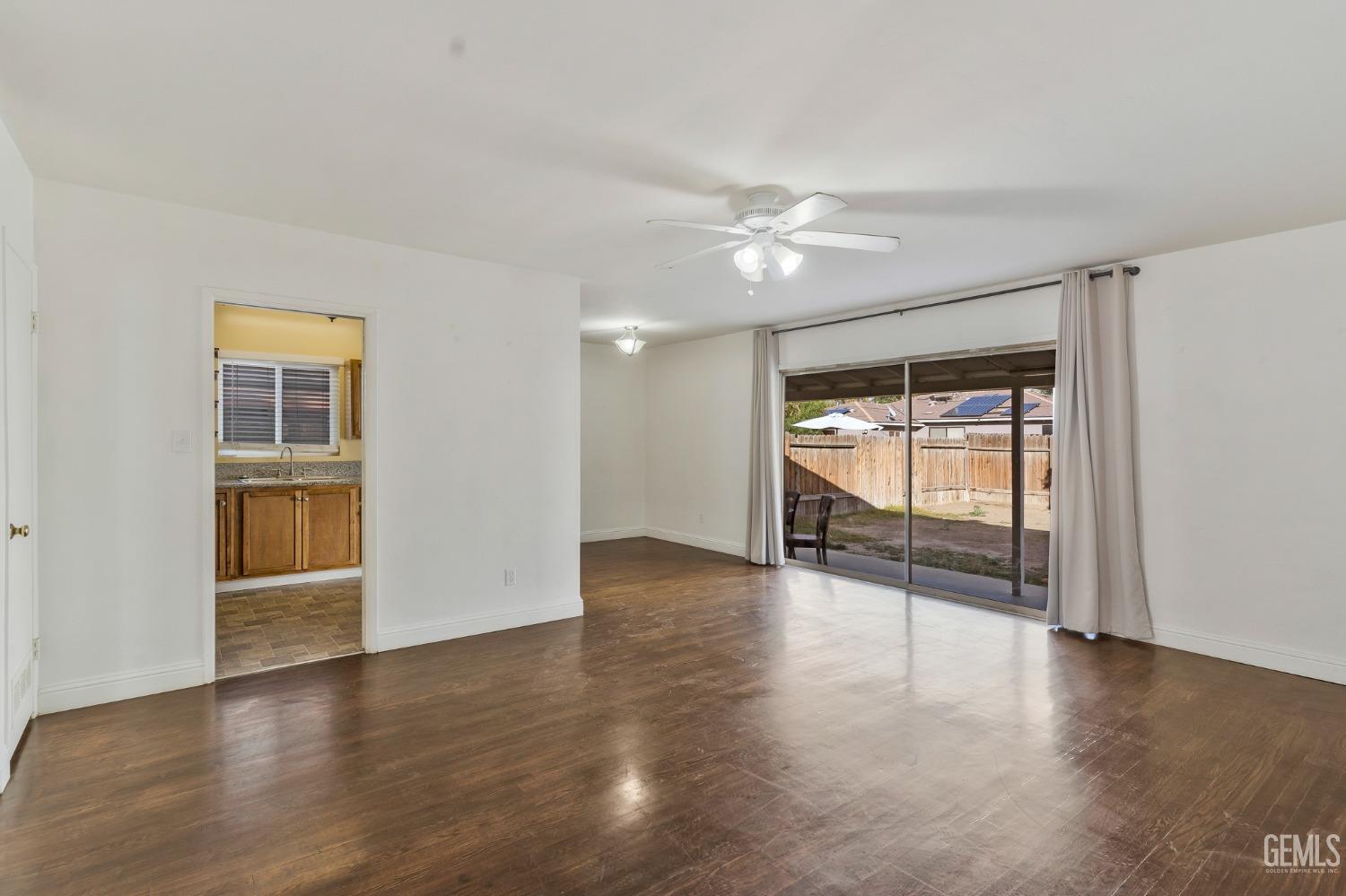 Undisclosed Address Bakersfield, CA 93304 - Photo 3 of 21 an empty room with wooden floor and a ceiling fan