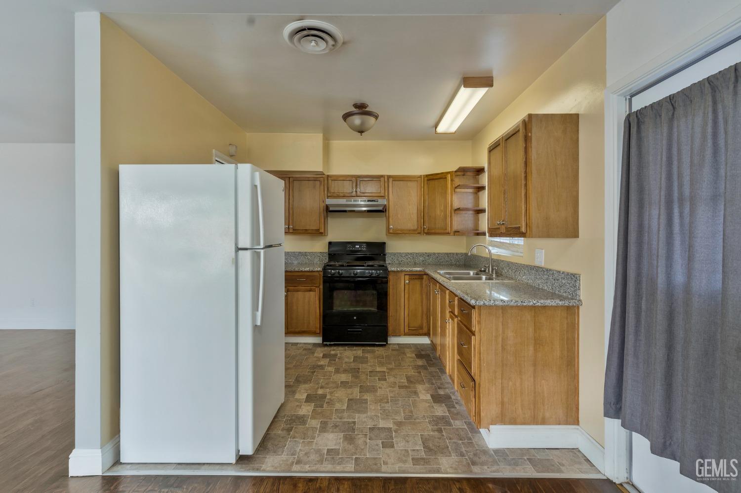 Undisclosed Address Bakersfield, CA 93304 - Photo 7 of 21 a kitchen with granite countertop a refrigerator and a sink