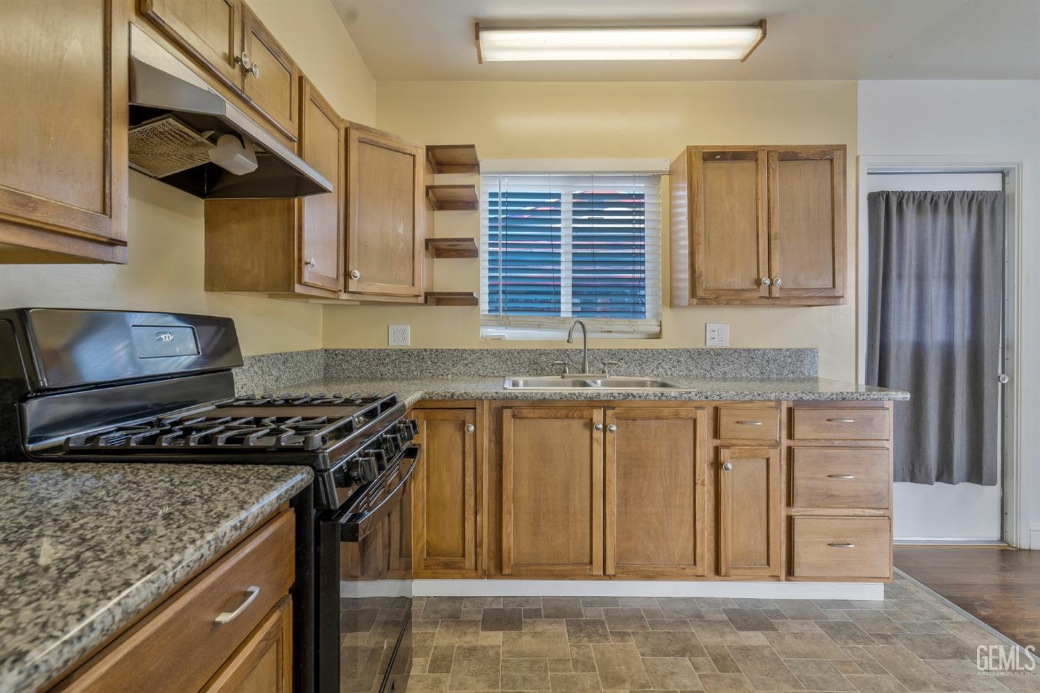 Undisclosed Address Bakersfield, CA 93304 - Photo 10 of 21 a kitchen with granite countertop a sink a stove and cabinets