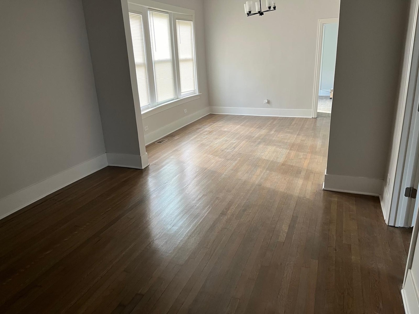 11578 South Perry Avenue Chicago, IL 60628 - Photo 3 of 11 an empty room with wooden floor and windows