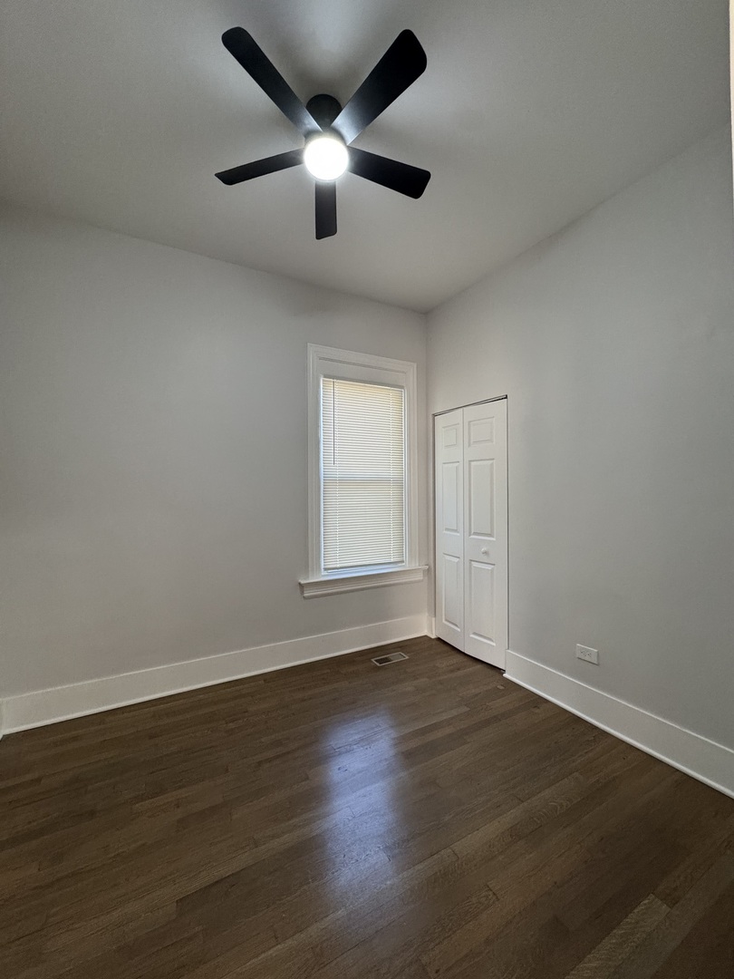 11578 South Perry Avenue Chicago, IL 60628 - Photo 5 of 11 an empty room with wooden floor and windows