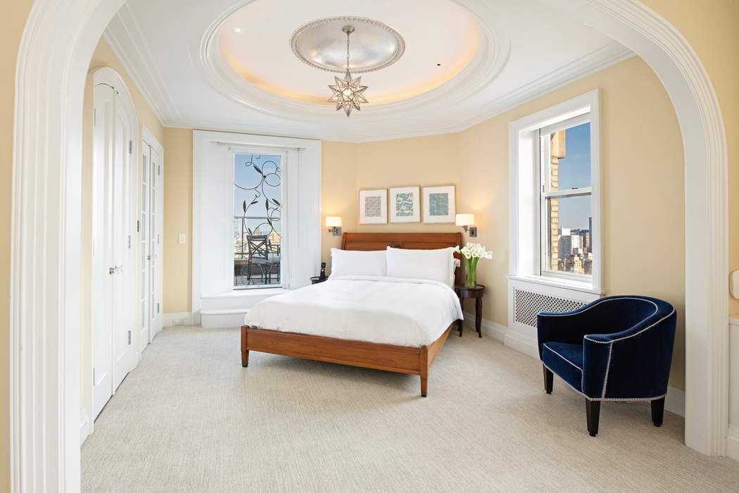 35 East 76th Street, Unit PH3407 Manhattan, NY 10021 - Photo 20 of 23 a bedroom with a bed and a chandelier