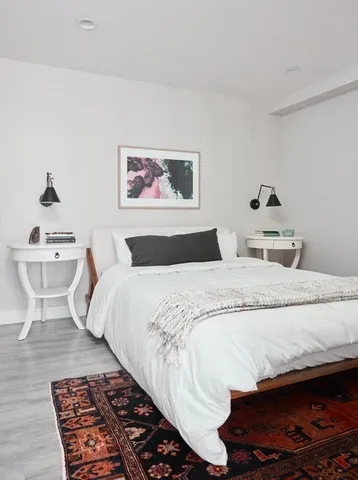 a bedroom with a large bed and a lamp on desk