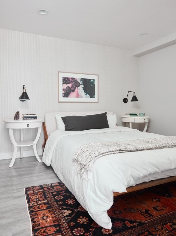 630 Washington Street, Unit 405 Boston, MA 02111 - Photo 9 of 10 a bedroom with a large bed and a lamp on desk