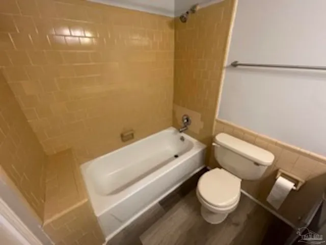 a white toilet sitting next to a bathroom sink and vanity