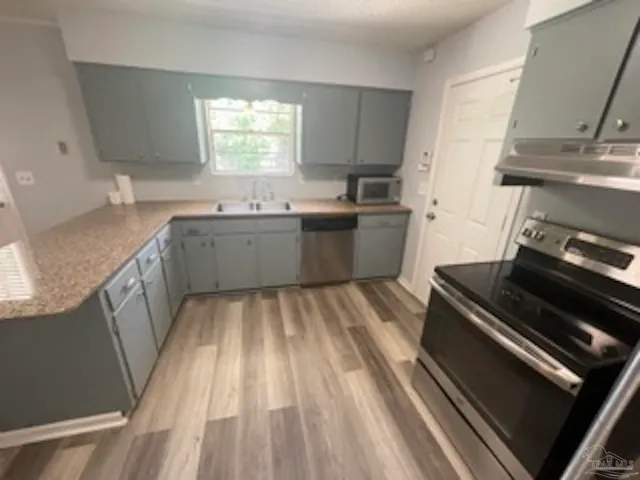 a kitchen with a sink stove and cabinets