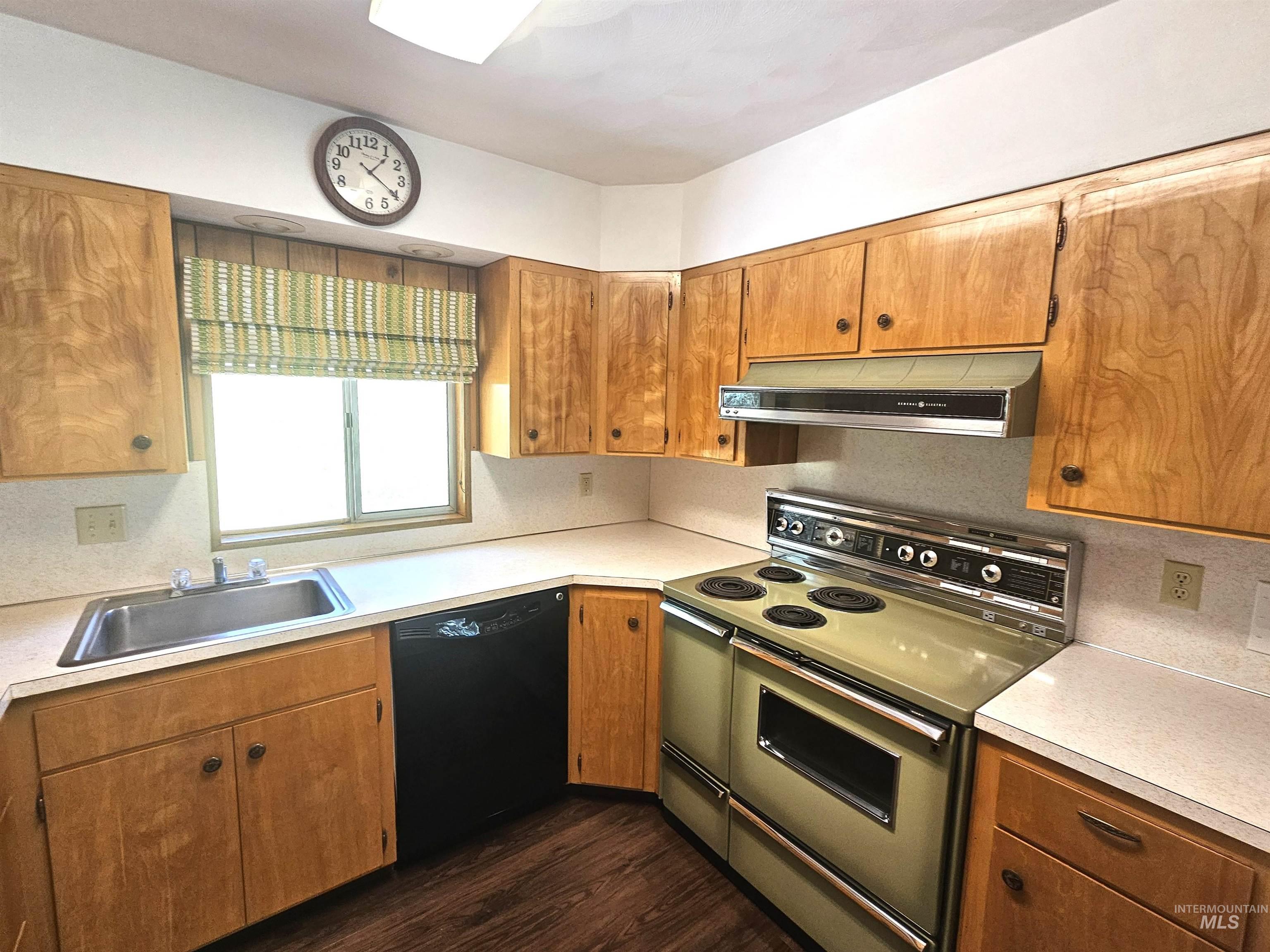 29865 Mission Creek Road Culdesac, ID 83524 - Photo 10 of 43 Kitchen featuring wood-finish cabinetry, solid surface countertops, a stainless steel sink, a black dishwasher, and a freestanding range with a coordinating range hood