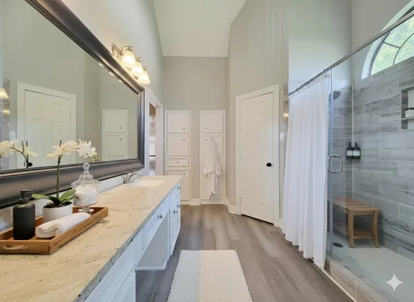 a bathroom with a granite countertop double vanity sink and a mirror