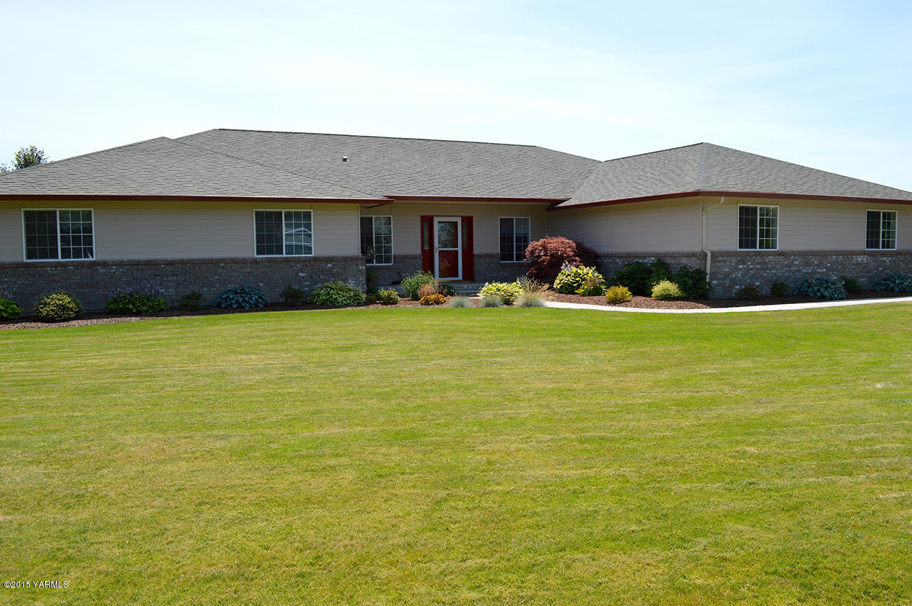 8104 Rutherford Road Yakima, WA 98903 - Photo 2 of 42 a view of a house with a yard and a table under an umbrella