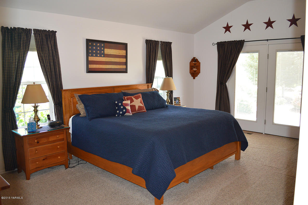 8104 Rutherford Road Yakima, WA 98903 - Photo 14 of 42 a bedroom with a bed and a dresser next to a window