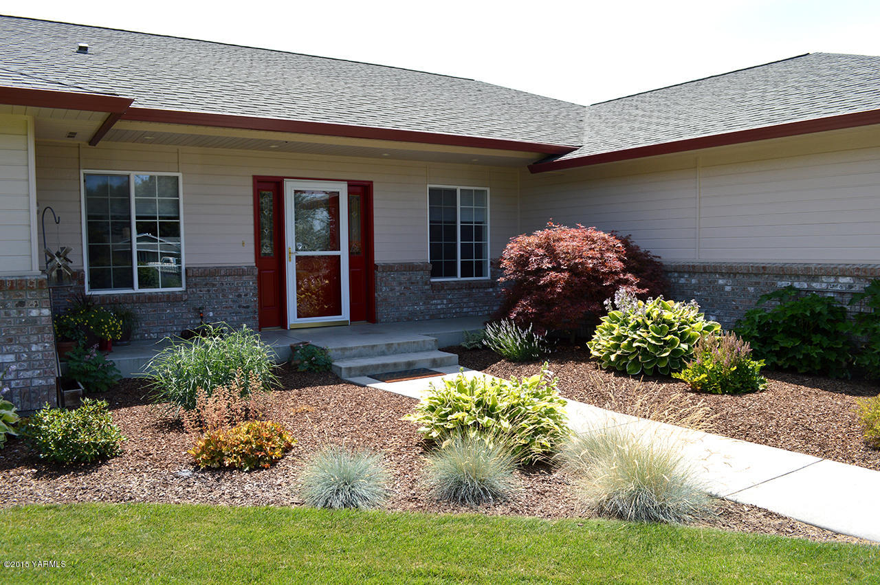 8104 Rutherford Road Yakima, WA 98903 - Photo 3 of 42 a front view of a house with a yard and flowers