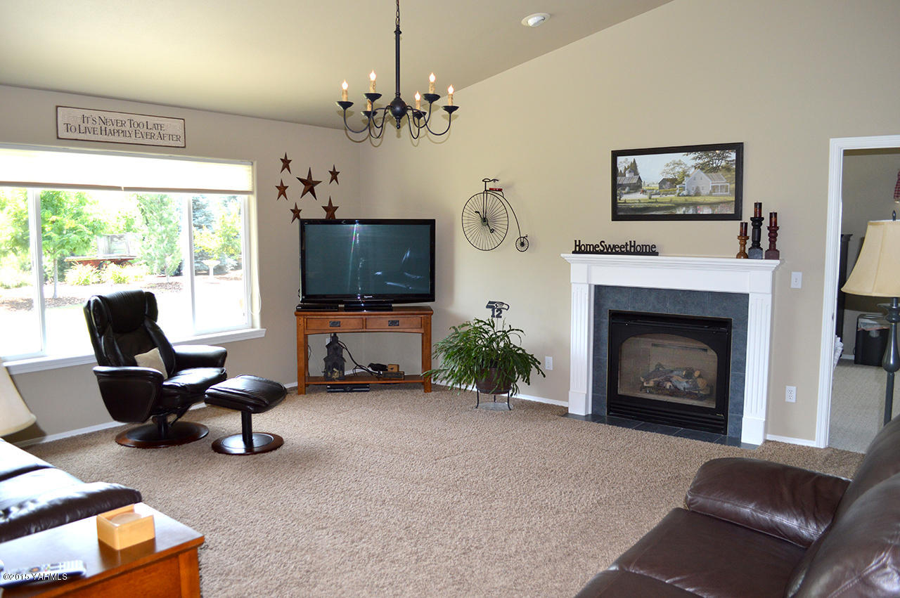 8104 Rutherford Road Yakima, WA 98903 - Photo 4 of 42 a living room with furniture a fireplace and a flat screen tv