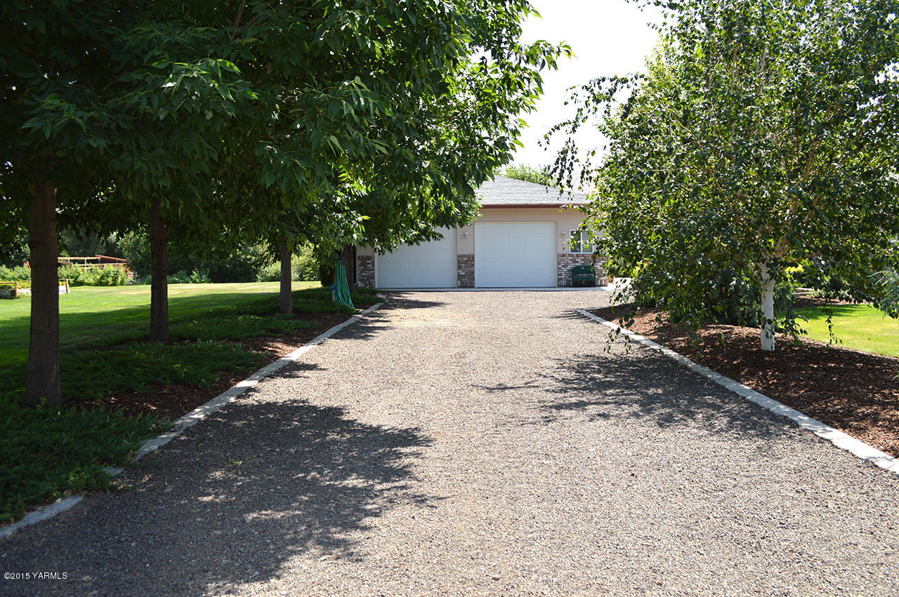 8104 Rutherford Road Yakima, WA 98903 - Photo 35 of 42 a front view of a house with a yard and tree s