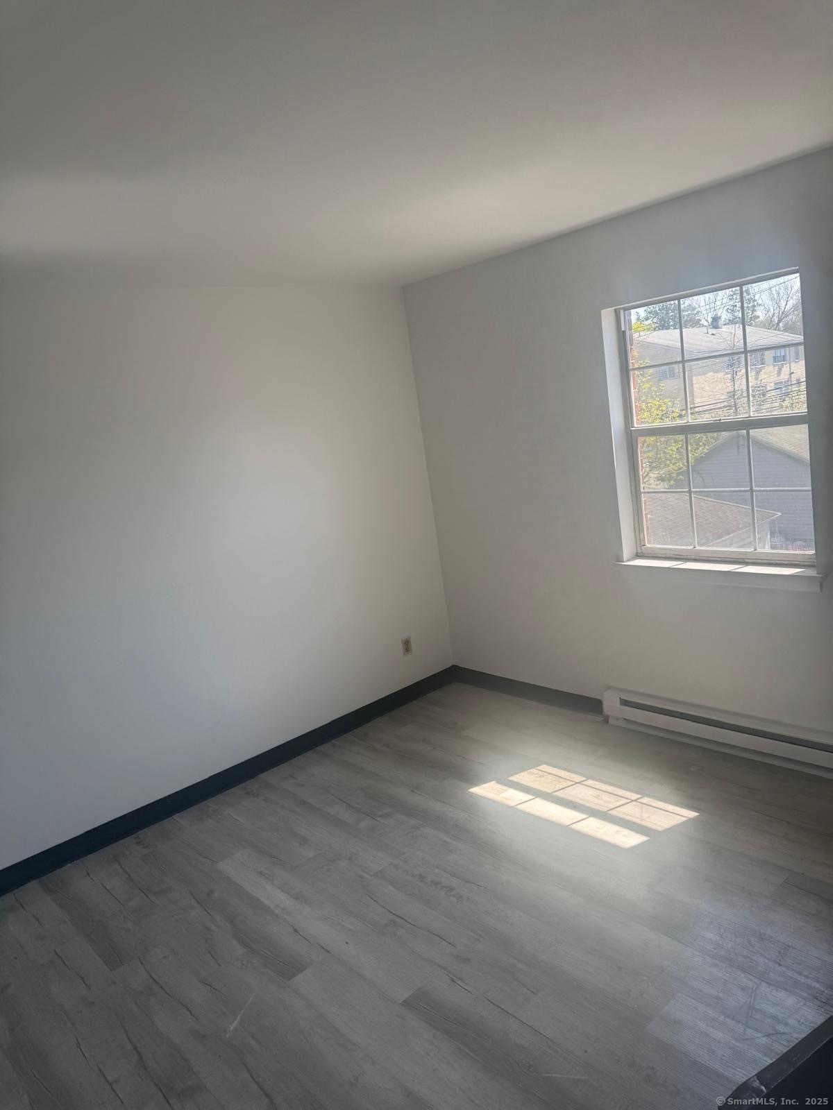 340 Palisade Avenue, Unit C8 Bridgeport, CT 06610 - Photo 2 of 2 an empty room with wooden floor and windows