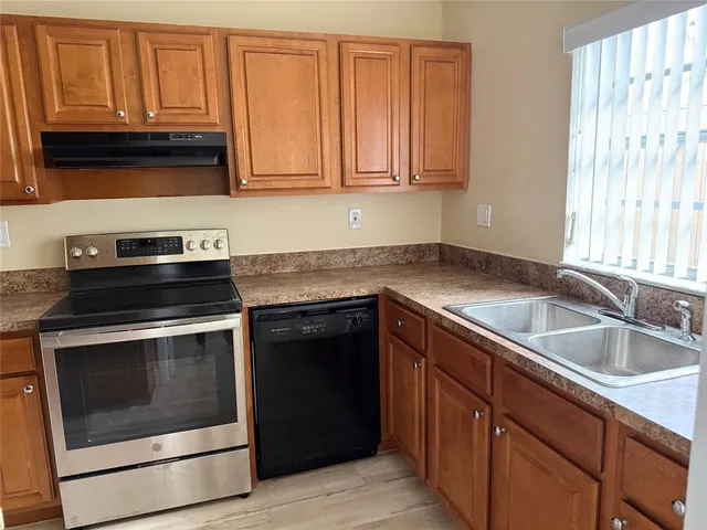 a kitchen with granite countertop cabinets stainless steel appliances and a sink