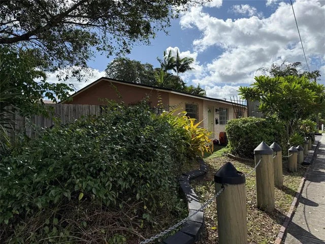 a view of backyard with seating space and wooden fence