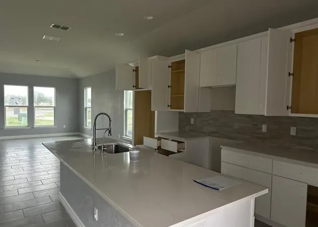 a kitchen with stainless steel appliances granite countertop a sink a stove and a refrigerator