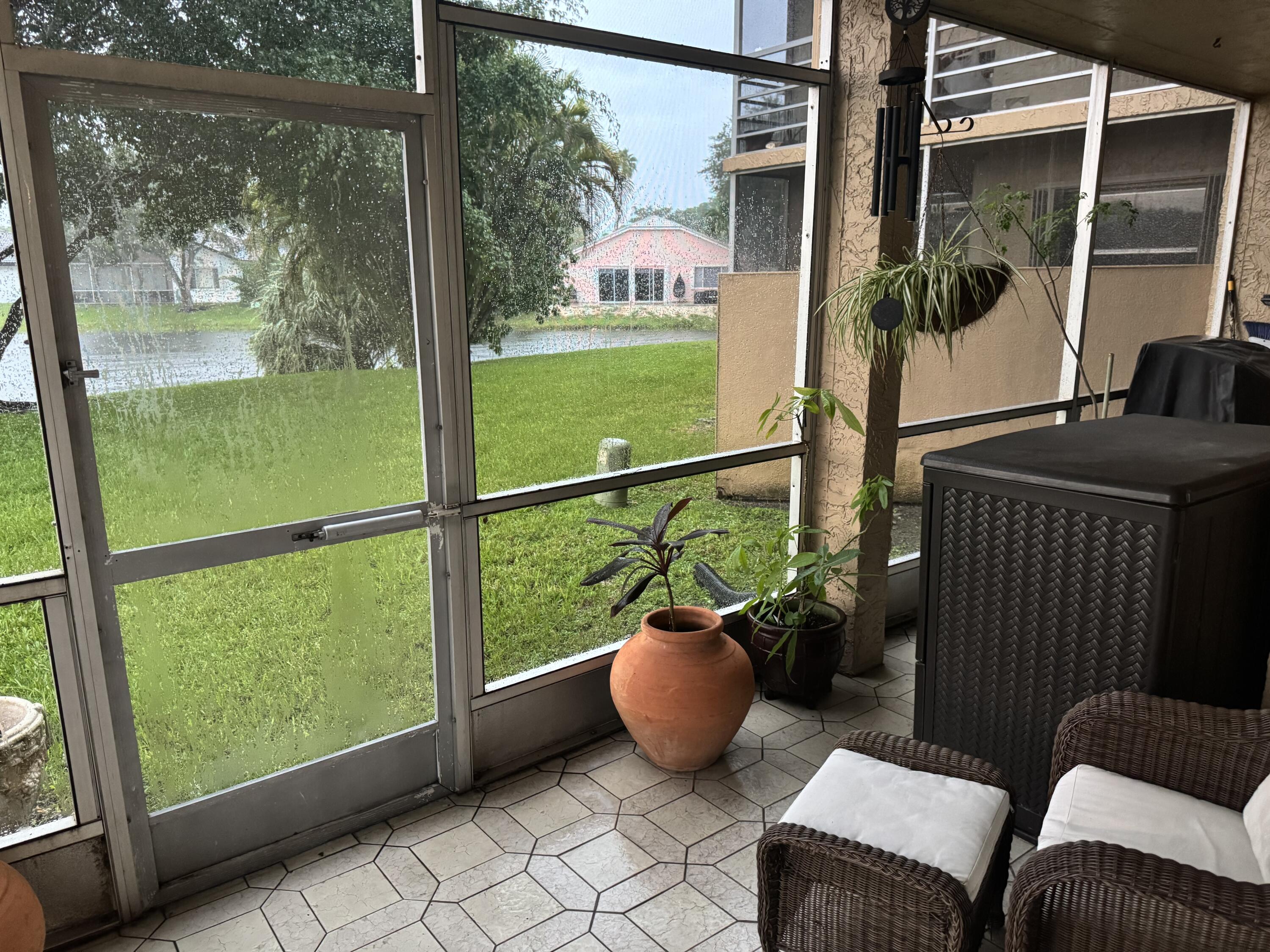 7531 Northwest 86th Terrace, Unit 101 Tamarac, FL 33321 - Photo 5 of 20 a view of a chair and tables in the balcony