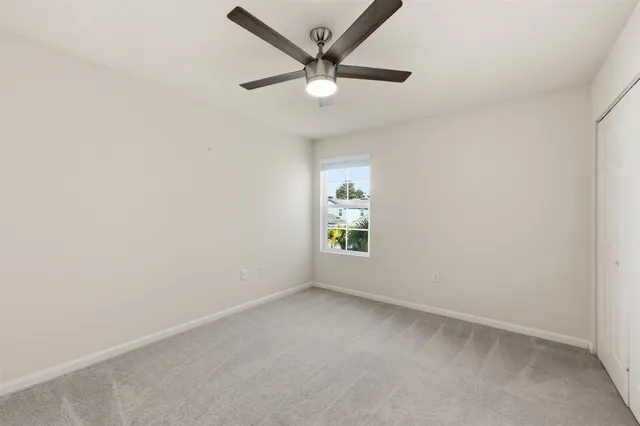 an empty room with a window and a fan
