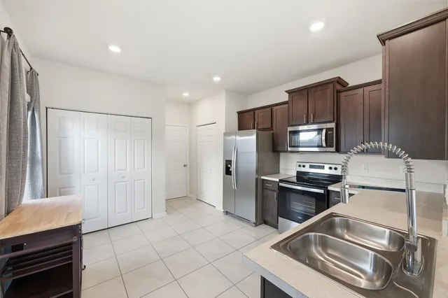 a kitchen with stainless steel appliances granite countertop a refrigerator and a stove top oven