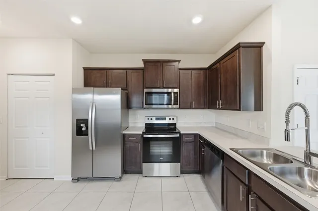 a kitchen with stainless steel appliances granite countertop a refrigerator sink and stove