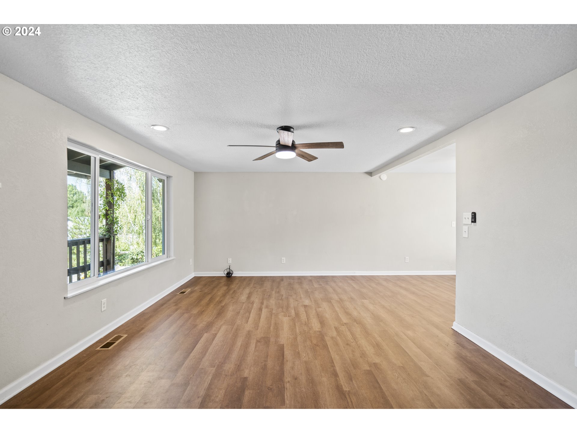 163 Christa Lane Eagle Point, OR 97524 - Photo 6 of 24 a view of an empty room with wooden floor and a window