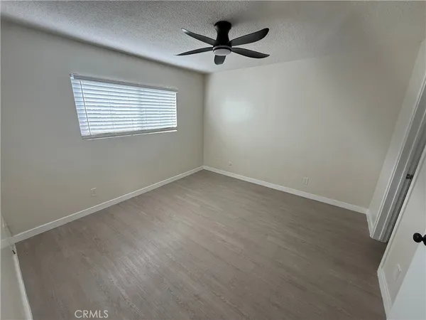 an empty room with a window and a fan