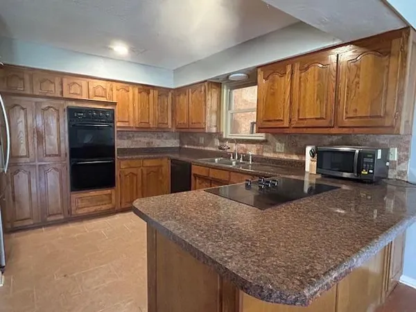 a kitchen with stainless steel appliances granite countertop a stove refrigerator and microwave