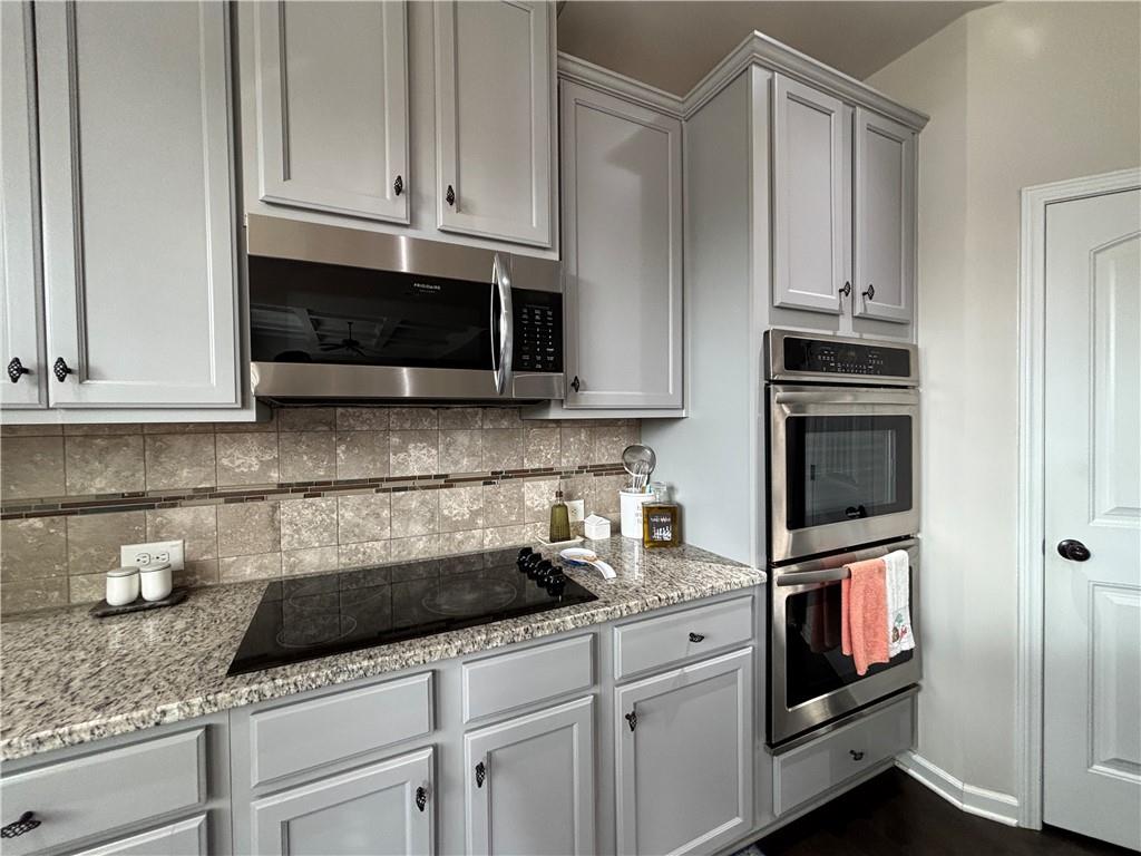 3459 In Bloom Way Auburn, GA 30011 - Photo 30 of 35 a kitchen with white cabinets and black appliances