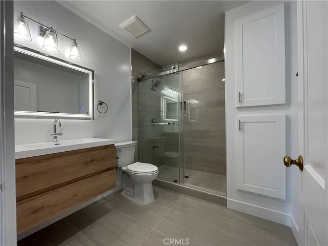 a bathroom with a double vanity sink toilet and shower
